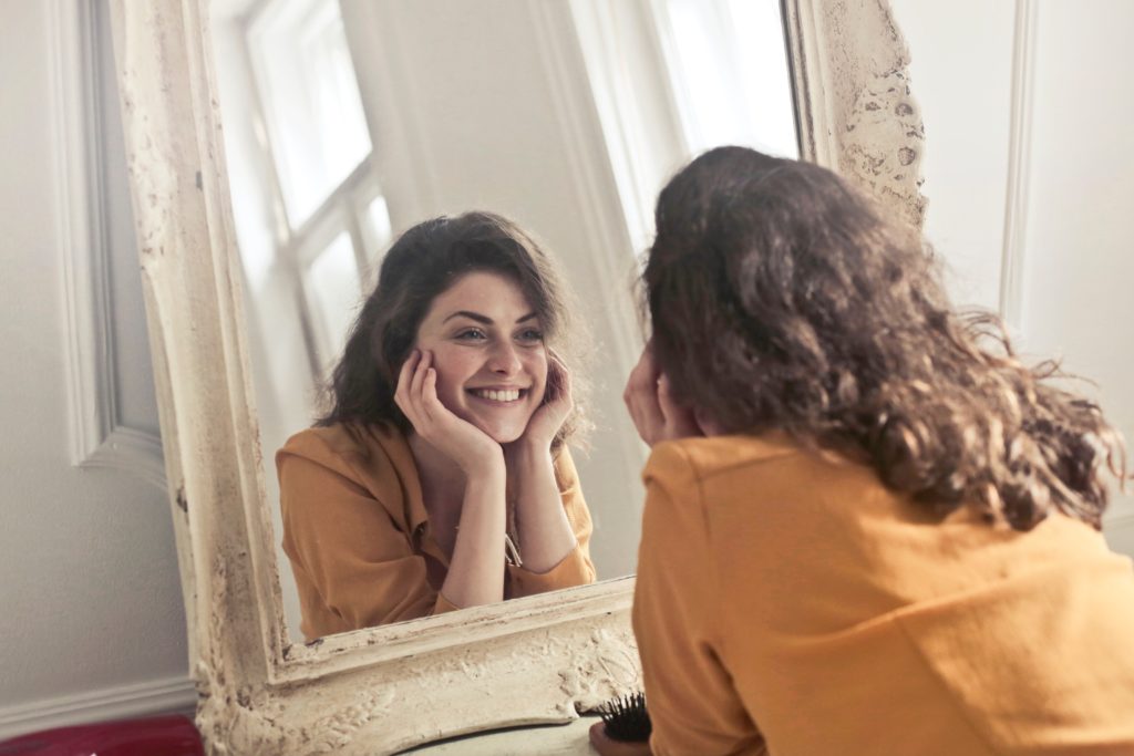 woman smiling at her mirror image