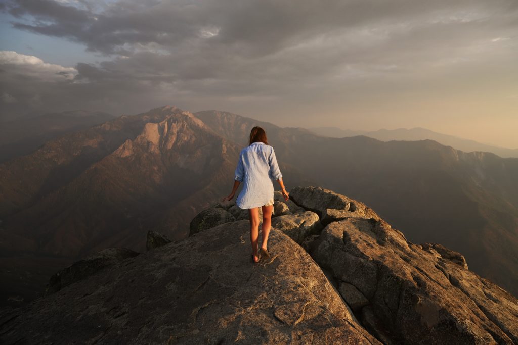 a woman facing rugged mountaintops