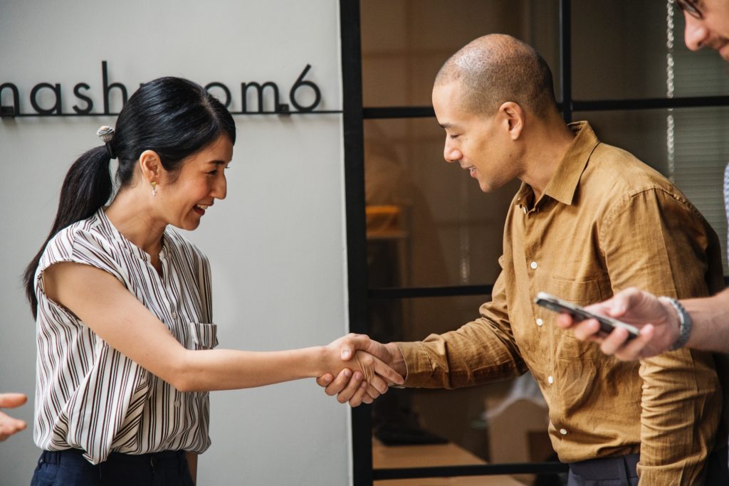 woman and man happily shaking hands