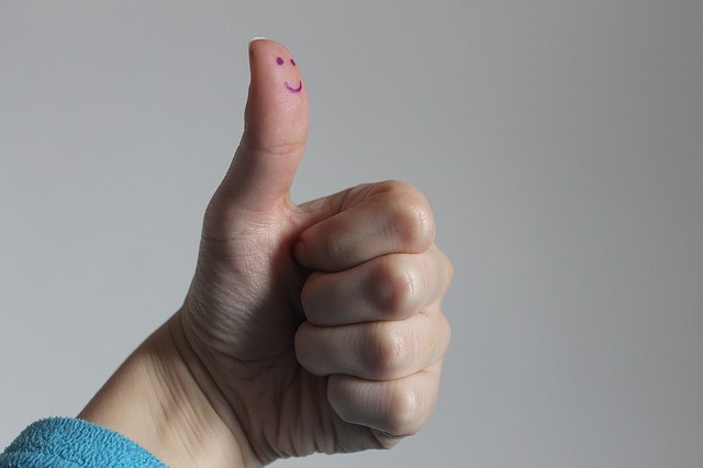a smiley on a thums up gesture